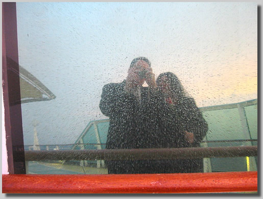 Dennis and Ruthie taking a picture on a cool rainy reflective surface on deck 10.