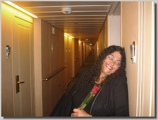 Ruthie posing in front of the long hallway that led to the cabins on deck 4 where our cabin was. This was on the way up to the formal dinner where I proposed to her. I had just given her a red rose and told her I loved her very much.