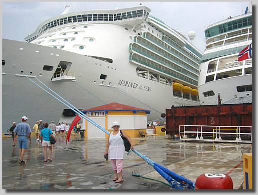 Ruthie on the dock at Cozumel, Mexico standing between our ship, Rhapsody of the Seas and Mariner of the Seas, which was almost twice as large as our ship.