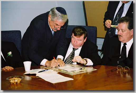 The men around the round table doin' bizness. The witnesses signing away.