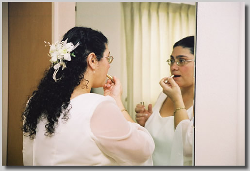 Rooty Jr. applying a few last minute beauty touches before the wedding in the bridal dressing room.