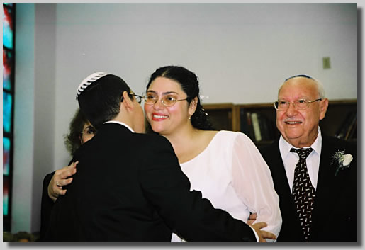 This is the wedding Processional with Rooty Jr. beaming as she is escorted in by Fortuna and Isaac, her parents. She is getting a kiss from Jonathan.